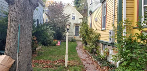 Outdoors near a yellow house